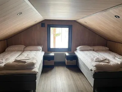 two beds in a small room with a window at Veltelia Resort in Nes i Ådal