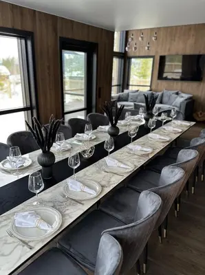 a long table with chairs and plates and wine glasses at Veltelia Resort in Nes i Ådal