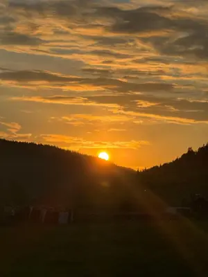 a sunset with the sun setting on a hill at Kjellerleilighet in Bjørge