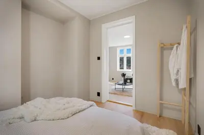 a white bedroom with a bed and a doorway at Stay Panorama - Best view in Bergen l 1-Bedroom in Bergen