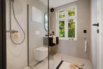 a bathroom with a shower and a toilet and a window at Stay Panorama - Best view in Bergen l 1-Bedroom in Bergen