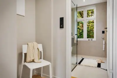 a white bathroom with a white chair and a shower at Stay Panorama - Best view in Bergen l 1-Bedroom in Bergen