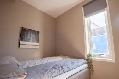 a bedroom with a bed and a window at 200 meters to Bryggen in charming Sandviken in Bergen