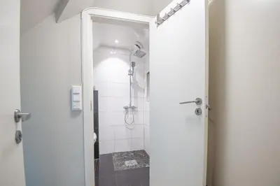 a bathroom with a shower and a glass door at 200 meters to Bryggen in charming Sandviken in Bergen