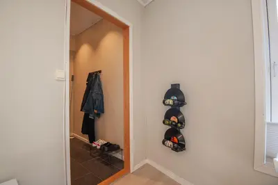 a hallway with a door to a room with shoes at 200 meters to Bryggen in charming Sandviken in Bergen
