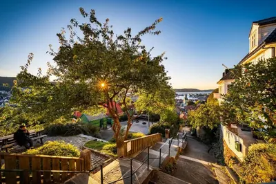 a person sitting on a bench on a city street at Stay Panorama - Best view in Bergen l Studio in Bergen