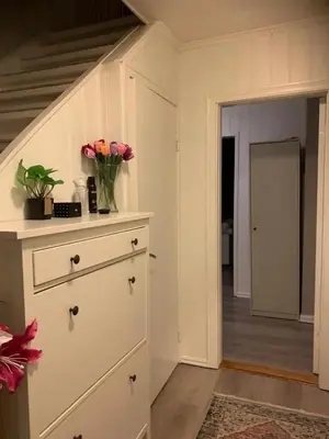 a kitchen with a dresser with a vase of flowers on it at Beautiful spacious home w garden in Trondheim