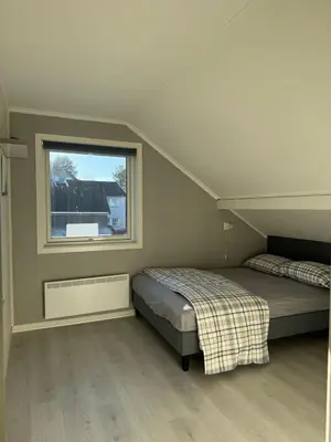 a bedroom with two beds and a window at Beautiful spacious home w garden in Trondheim