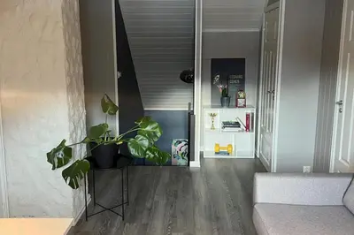 a living room with a potted plant and a hallway at Scenic Private House Surrounded by Nature in Sæbø