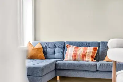 a blue couch with orange pillows in a living room at Urban Elegant Apartment in Bergen