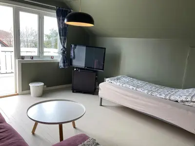 a living room with a couch and a table and a tv at Short way to city centre and Aker Solutions! in Stord