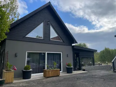 a black and white house with potted plants at Modern holiday home in Ålesund