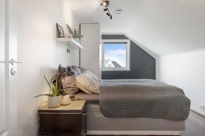 a bedroom with a bed and a window at Beachfront Villa with Jacuzzi, Cinema & Canoe in Bergen