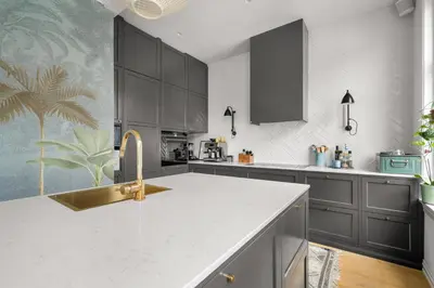 a kitchen with black cabinets and a white counter top at Historic Townhouse I With Rooftop & Free Parking in Bergen