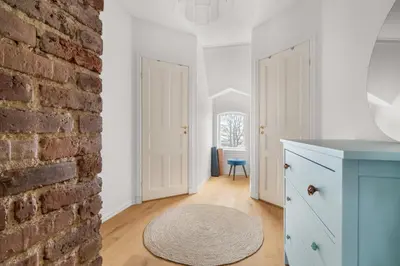 a kitchen with a blue cabinet and a brick wall at Historic Townhouse I With Rooftop & Free Parking in Bergen