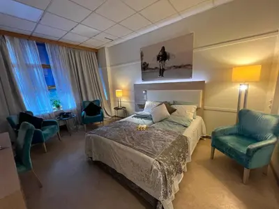 a bedroom with a bed and two chairs in it at Dokka Motell in Dokka