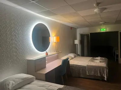 a hotel room with two beds and a mirror at Dokka Motell in Dokka