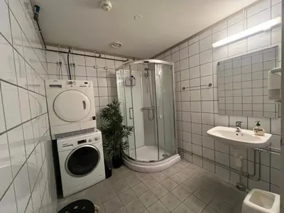 a bathroom with a shower sink and a washing machine at Dokka Motell in Dokka