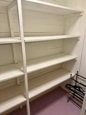 a closet with white shelves in a room at Leilighet i under etasje in Lillehammer