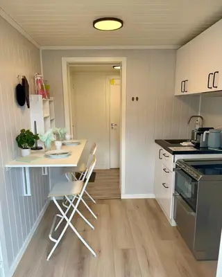a kitchen with a table and two chairs in it at Leilighet i under etasje in Lillehammer