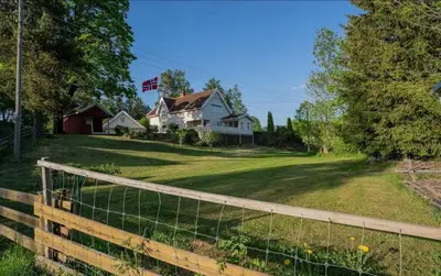 a fence in front of a yard with houses at Cozy rooms with private bathroom close to Hønefoss in Knestang
