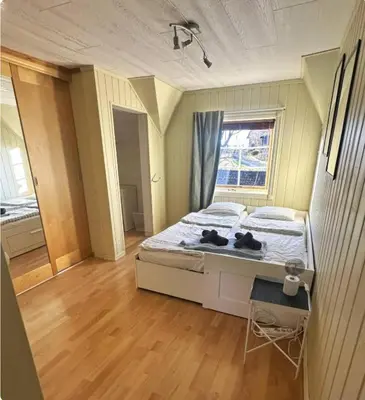 a bedroom with a bed with two cats laying on it at Cozy rooms with private bathroom close to Hønefoss in Knestang