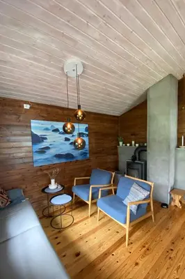 a living room with blue chairs and a table at Cabin by Oppstrynsvatnet, Hjelle in Stryn