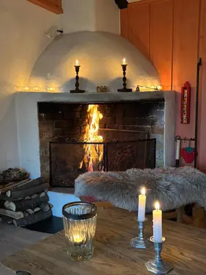 a living room with a fireplace with candles on a table at Authentic Norwegian chalet for 8 with fireplaces & modern comfort near Geilo ski slopes in Geilo