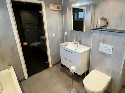 a bathroom with a toilet and a sink and a mirror at 4 star holiday home in Tjeldstø in Tjeldstø