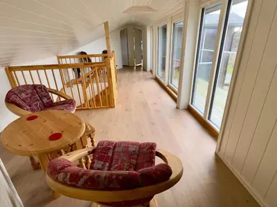 a living room with a table and chairs and windows at 4 star holiday home in Tjeldstø in Tjeldstø