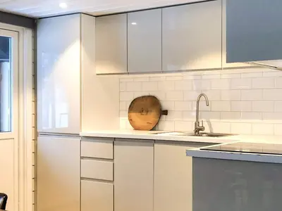 a kitchen with white cabinets and a wooden bowl on the counter at 8 person holiday home in Hemsedal in Hemsedal