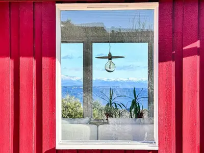 a window of a house with a view of the mountains at 6 person holiday home in KLOKKARVIK in Klokkarvik