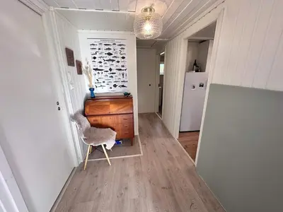 a hallway with a chair and a dresser in a room at 6 person holiday home in KLOKKARVIK in Klokkarvik