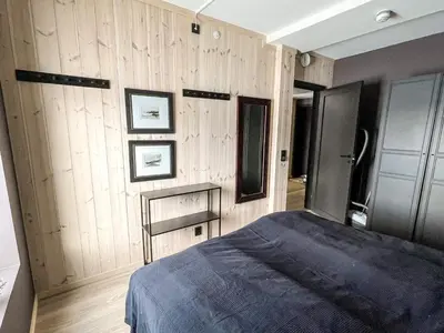 a bedroom with wooden walls and a blue bed at 4 star holiday home in Hemsedal in Hemsedal