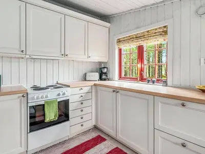 a kitchen with white cabinets and a stove and a window at 5 person holiday home in Røros in Røros