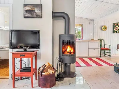 a fireplace in a living room with a tv at 5 person holiday home in Røros in Røros