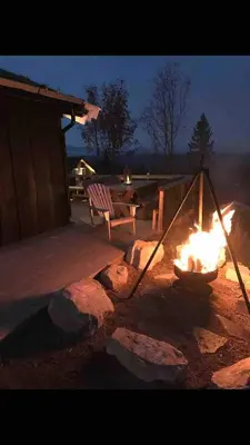 a fire pit with a bench and a table at Bjønnhiet in Trysil