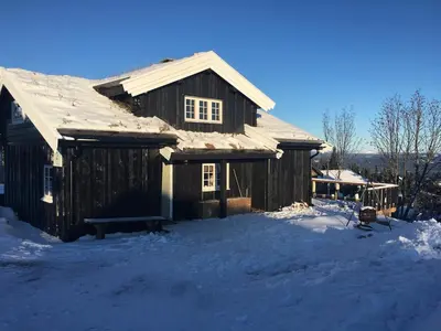 a wooden house with snow on the ground at Bjønnhiet in Trysil