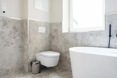 a bathroom with a toilet and a sink and a window at Large apartment in historical street in Bergen