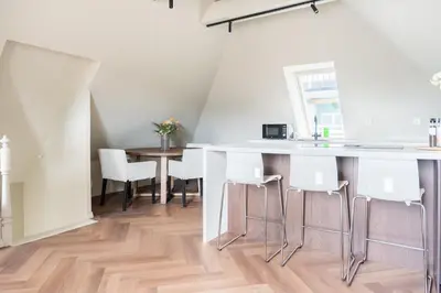 a kitchen with a counter and a table and chairs at Large apartment in historical street in Bergen
