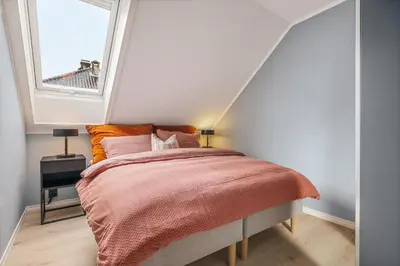 a bedroom with a bed with a large window at Rosenberg Apartments in Bergen