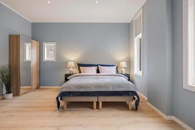 a bedroom with a large bed with blue walls at Rosenberg Apartments in Bergen