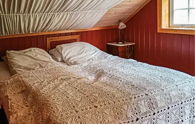 a bed in a room with a red wall at Nice Home In Stårheim With Wifi in Stårheim