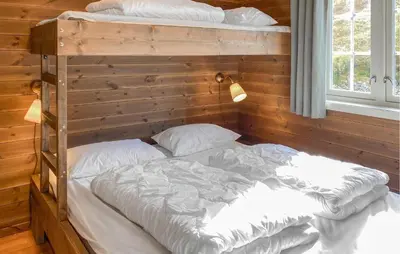 a bedroom with two bunk beds in a wooden wall at 2 Bedroom Cozy Apartment In Stranda in Stranda