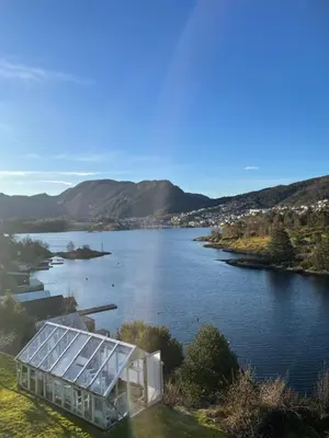 a glass house on the shore of a lake at Sjøutsikt in Bergen