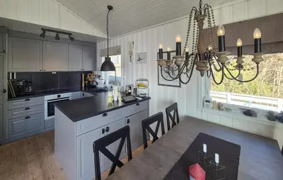 a kitchen with a dining table and a chandelier at Lovely Home In Mosterhamn With Sauna in Mosterhamn