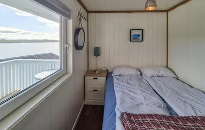 a bedroom with a bed next to a window at Lovely Home In Mosterhamn With Sauna in Mosterhamn