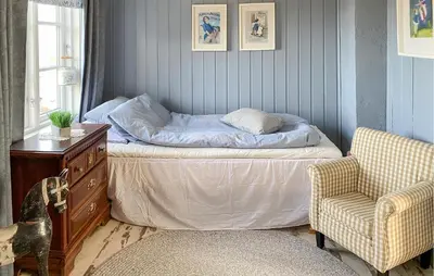 a bedroom with a bed and a chair and a dresser at Amazing Home In Averøy With Wifi in Averoy