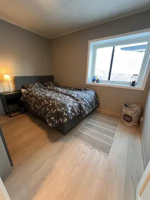 a bedroom with a bed and a window at Mountain View apartment in Isfjorden