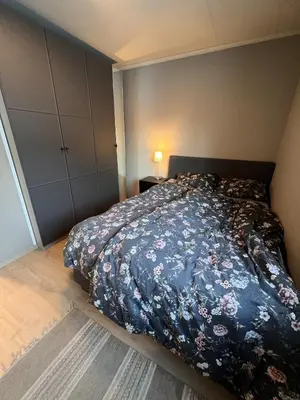 a bedroom with a bed with a blue comforter at Mountain View apartment in Isfjorden